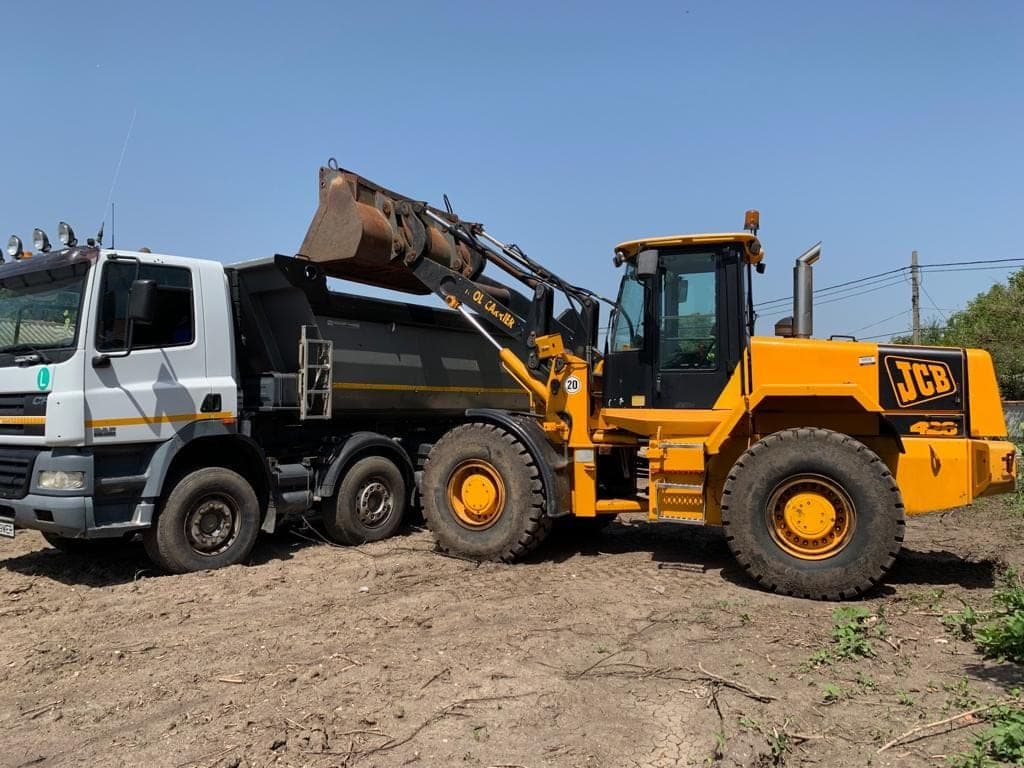 Wheel loader și autobasculantă pentru transport deșeu vegetal post-defrișare — Demolex